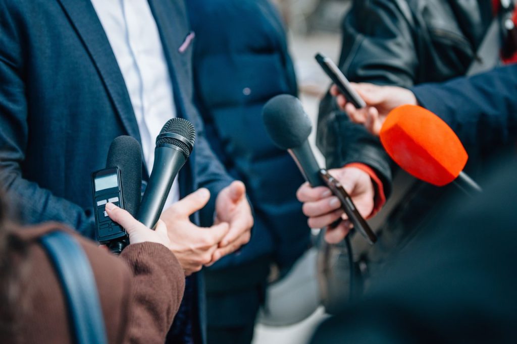 Vairāki mikrofoni un diktofons pastiepti pret intervējamo cilvēku preses konferencē